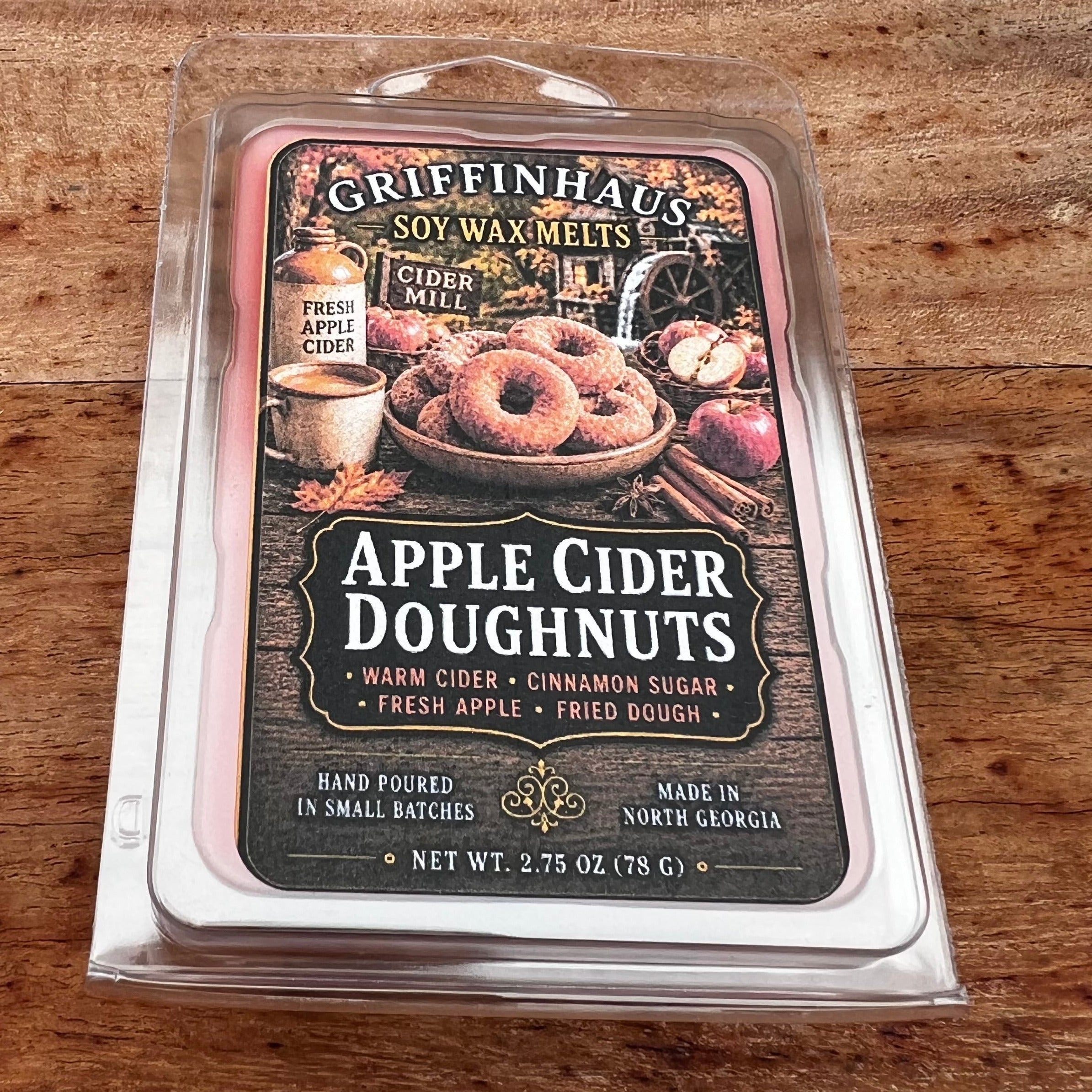 Griffenhaus Apple Cider Doughnuts soy wax melts in a clear plastic clamshell package, placed on a rustic wooden surface.